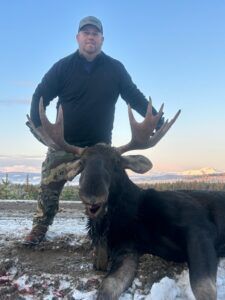 Three Peak Outfitters moose hunt late fall forest alberta man lifting up moose head