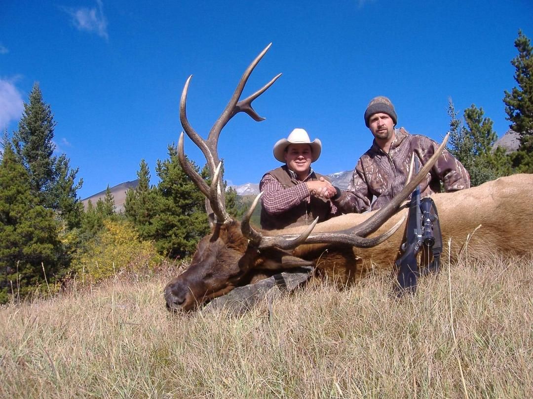 Three Peak Outfitters successful elk hunt on hill hunter shaking hands with Donald alberta