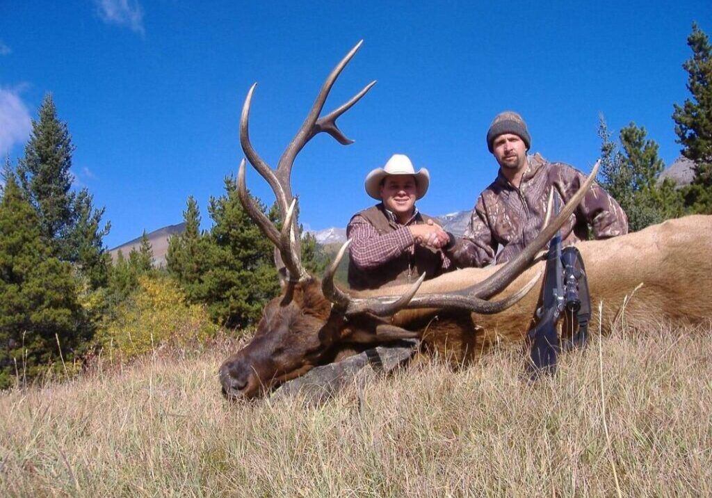 Three Peak Outfitters successful elk hunt on hill hunter shaking hands with Donald alberta